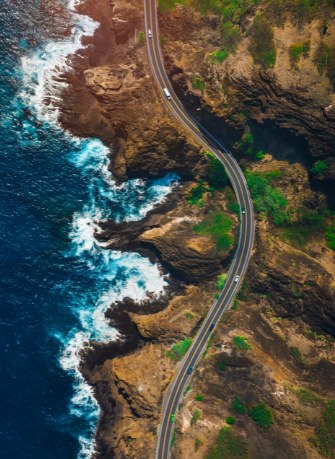A coastal highway curving along a cliff edge, seen from above