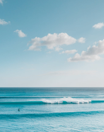 Gentle surf breaking on a white-sand shore